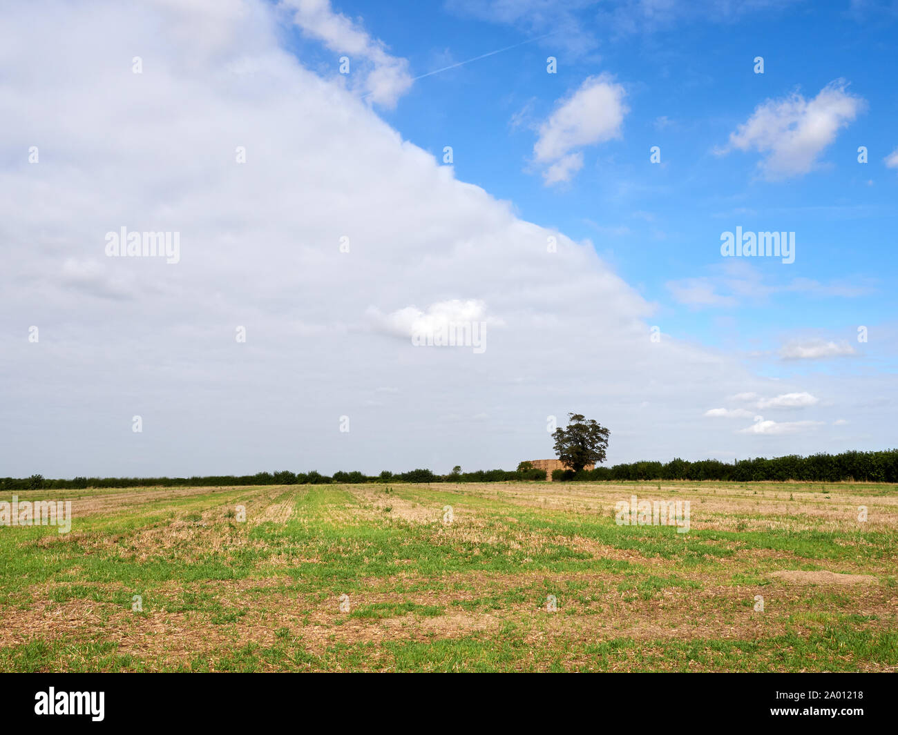 Wolken bilden eine kalte Wetter vor die Aufteilung der Himmel bewölkt halb und halb klar blau über Lincolnshire Ackerland der Arbeitsscheinwerfer zur Kontrolle der Schnitthöhe Stockfoto