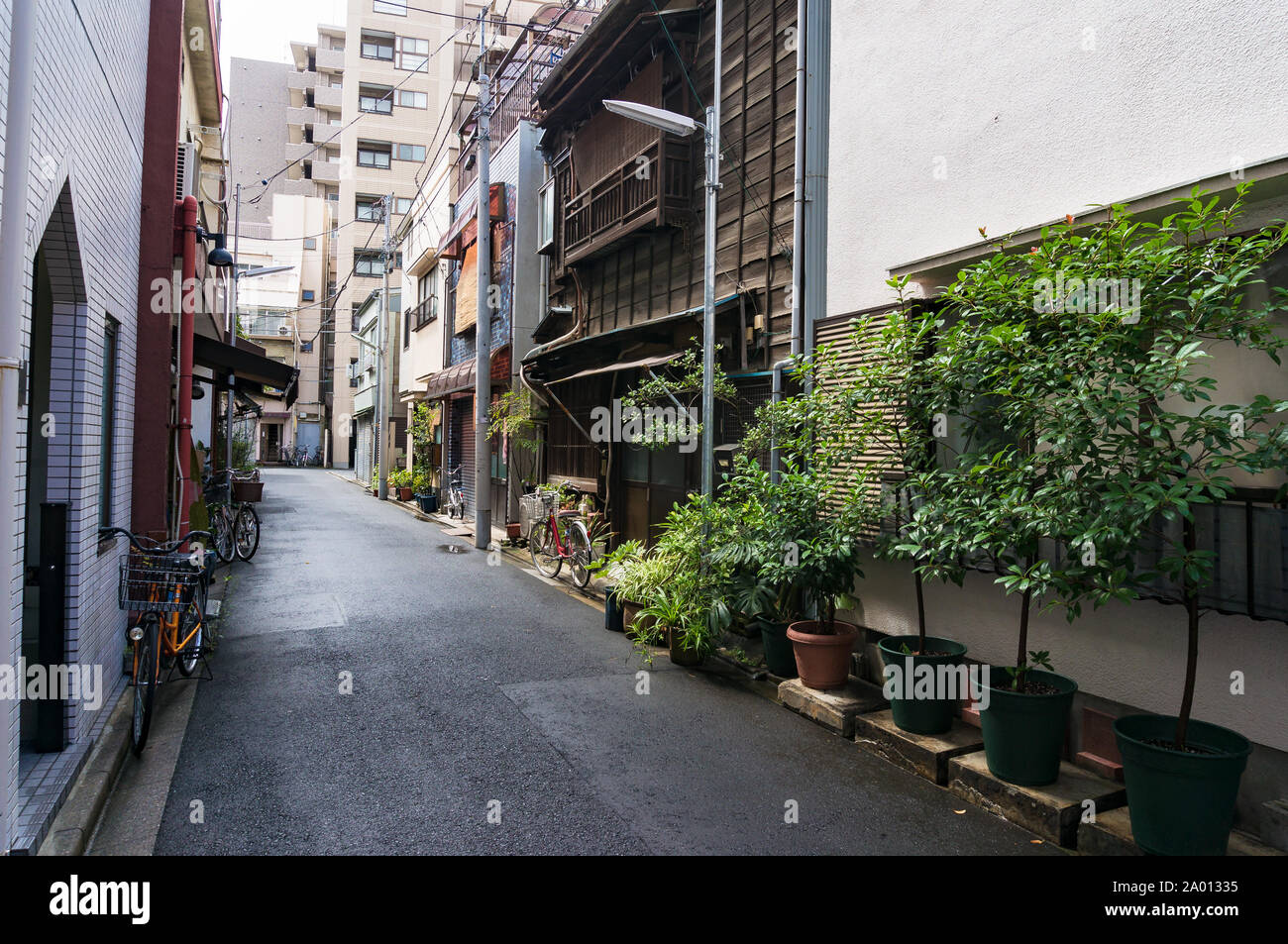 Kleine Straße mit traditionellen japanischen Holzhaus angeheftet unter den modernen Gebäuden. Alltag Stockfoto