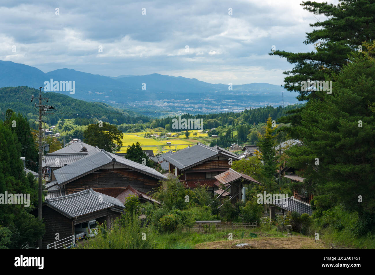 Blick von oben auf Magome plz Holzbauten und Reis Bauernhöfe mit Bergen im Hintergrund. Kiso Tal, Präfektur Gifu, Japan Stockfoto