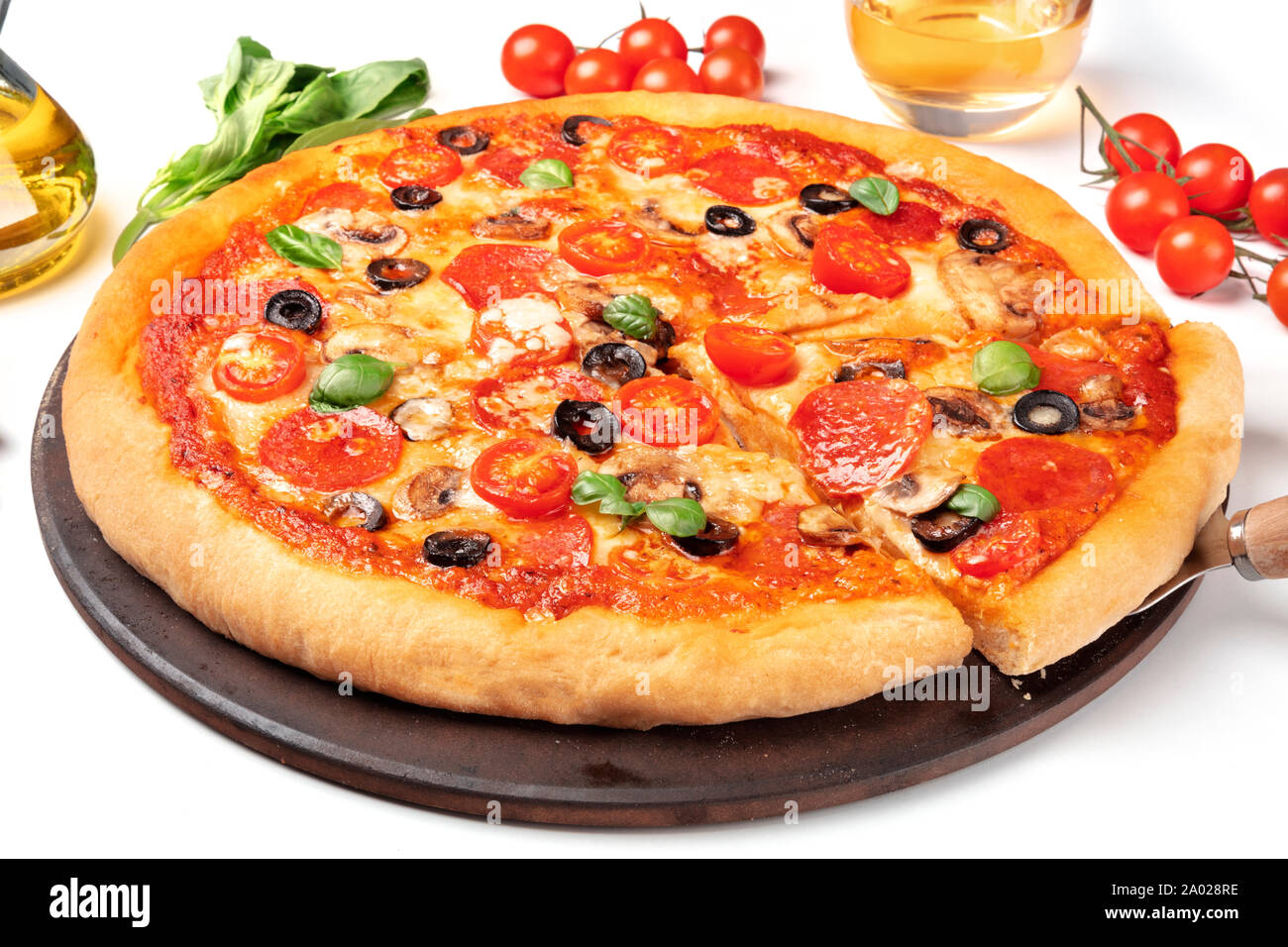 Pepperoni Pizza mit Salami Scheiben, schwarze Oliven, Champignons, frische Basilikumblätter und viel Käse Stockfoto