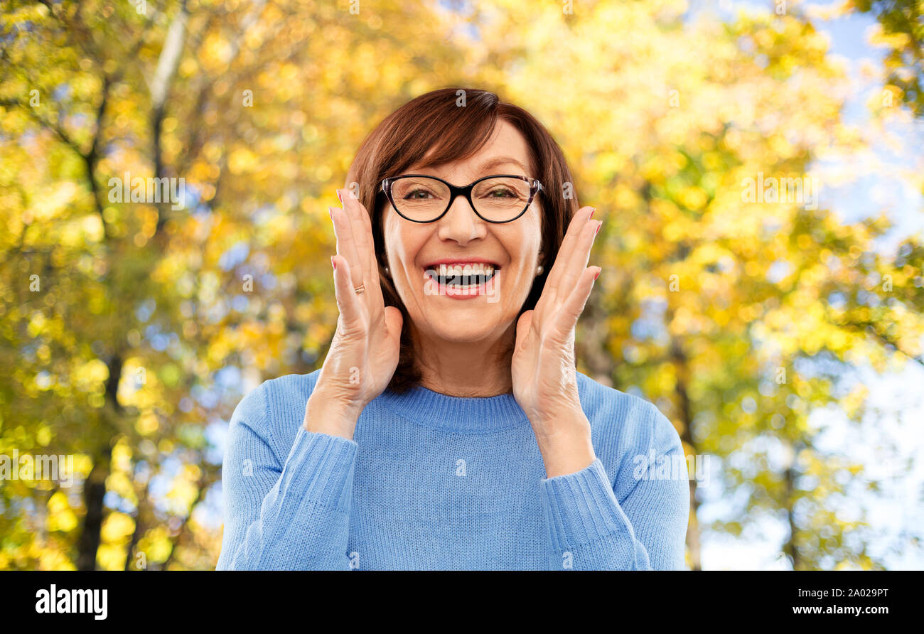 Ältere Frau in Gläser Aufruf über Herbst Park Stockfoto