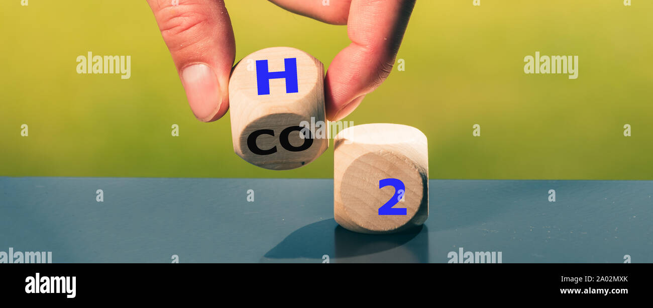 Änderung der Brennstoffzellenfahrzeuge. Hand, dreht sich ein Würfel und ändert den Ausdruck CO2 und H2. Stockfoto