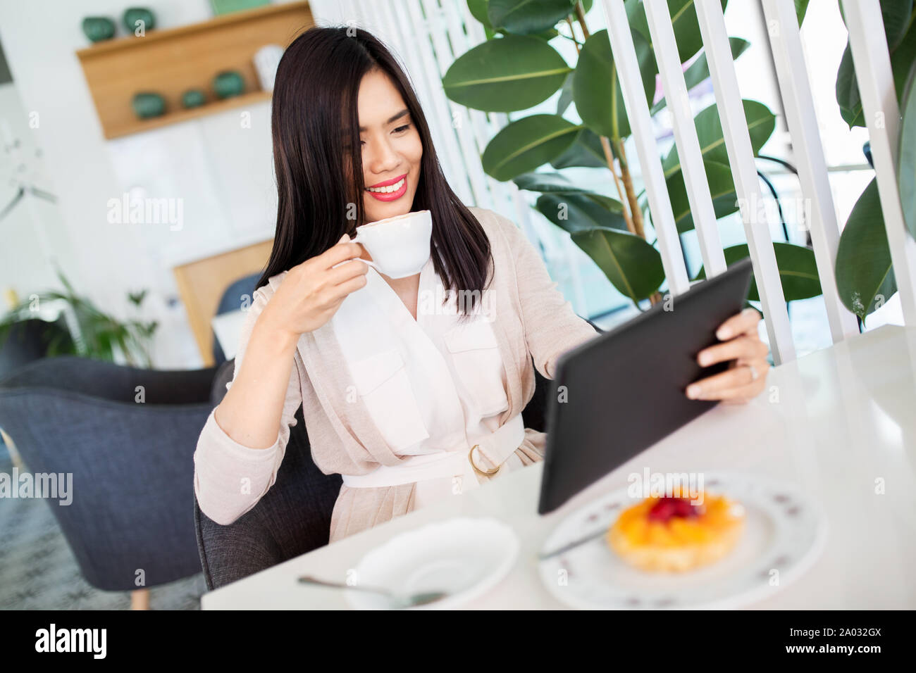 Asiatische Frau mit Tablet-PC im Cafe oder Tee Shop Stockfoto