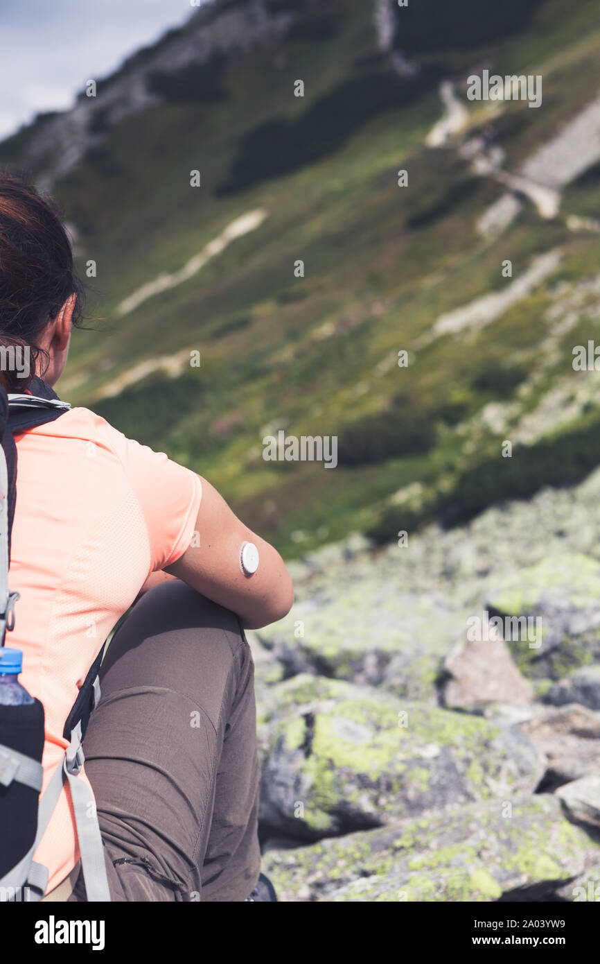 Das aktive Leben der Diabetiker, Frau, die sich an den Berghang mit neuer Technologie remote Sensor auf der Hand. Violett getönten Bild. Stockfoto