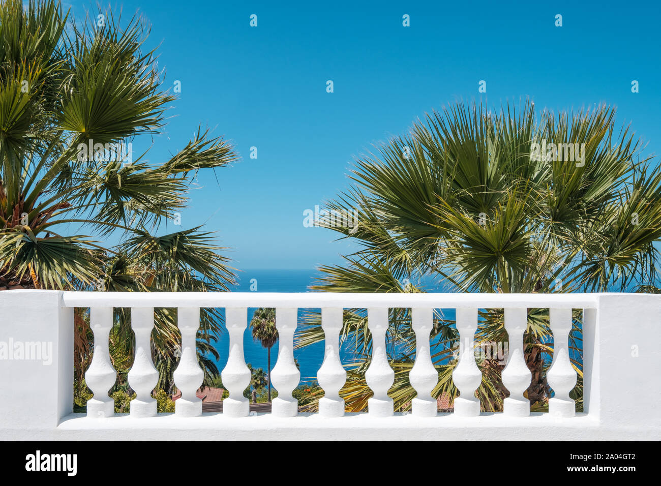 Balluster Terrasse mit Blick aufs Meer, blauer Himmel und Palmen - Hintergrund Stockfoto