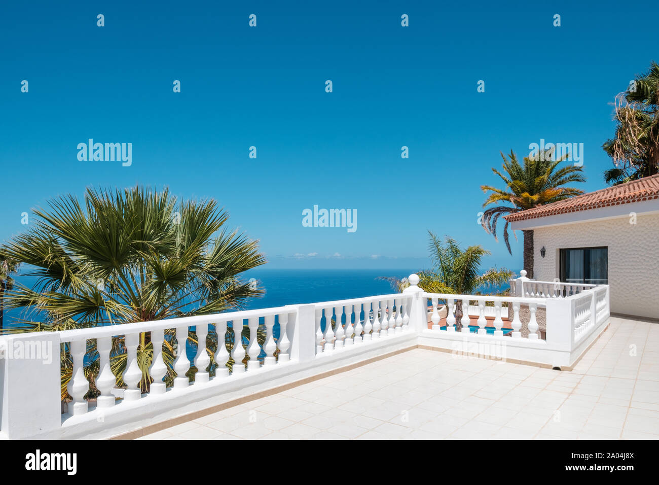 Villa mit Meerblick Terrasse, blauer Himmel und Palmen - Hintergrund Stockfoto