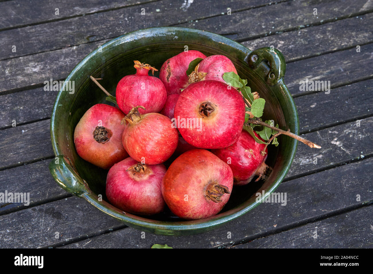 Noch immer leben einer Metallschale mit frisch geernteten Granatäpfel auf hölzernen Tisch Stockfoto