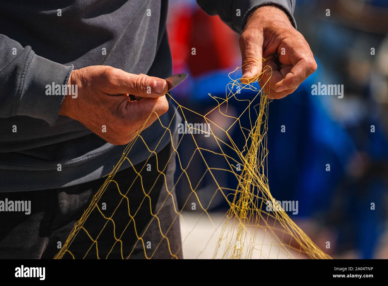 Detail in der Nähe von Fisherman Hände net Reparatur mit Messer. Selektive konzentrieren. Stockfoto