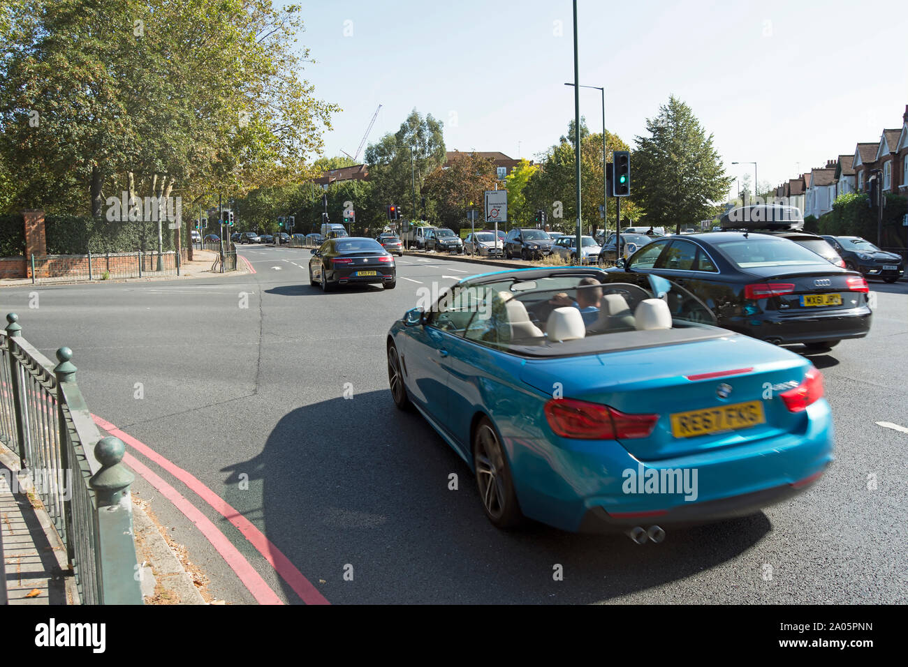 Autos Kreuzung Ecke chalkers, einer belebten Kreuzung mit Ampel im Südwesten von London, England Stockfoto