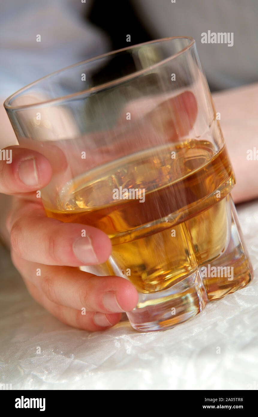 Zarte Frauenhand mit einem Glas Schnaps, weibliche Alkoholismus Stockfoto