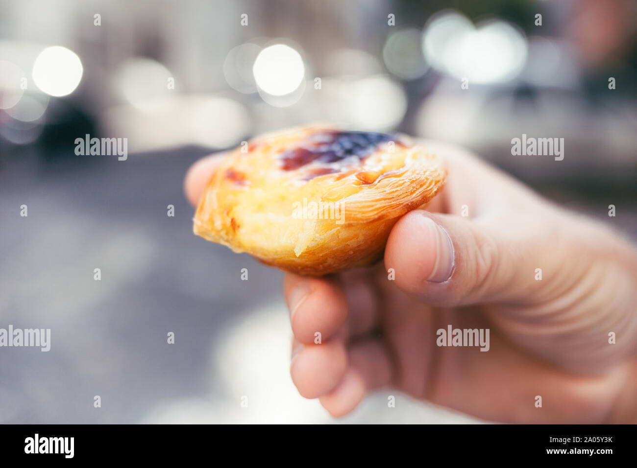 Traditionelle portugiesische Dessert in der Hand des Menschen. Pastel de Nata. Stockfoto