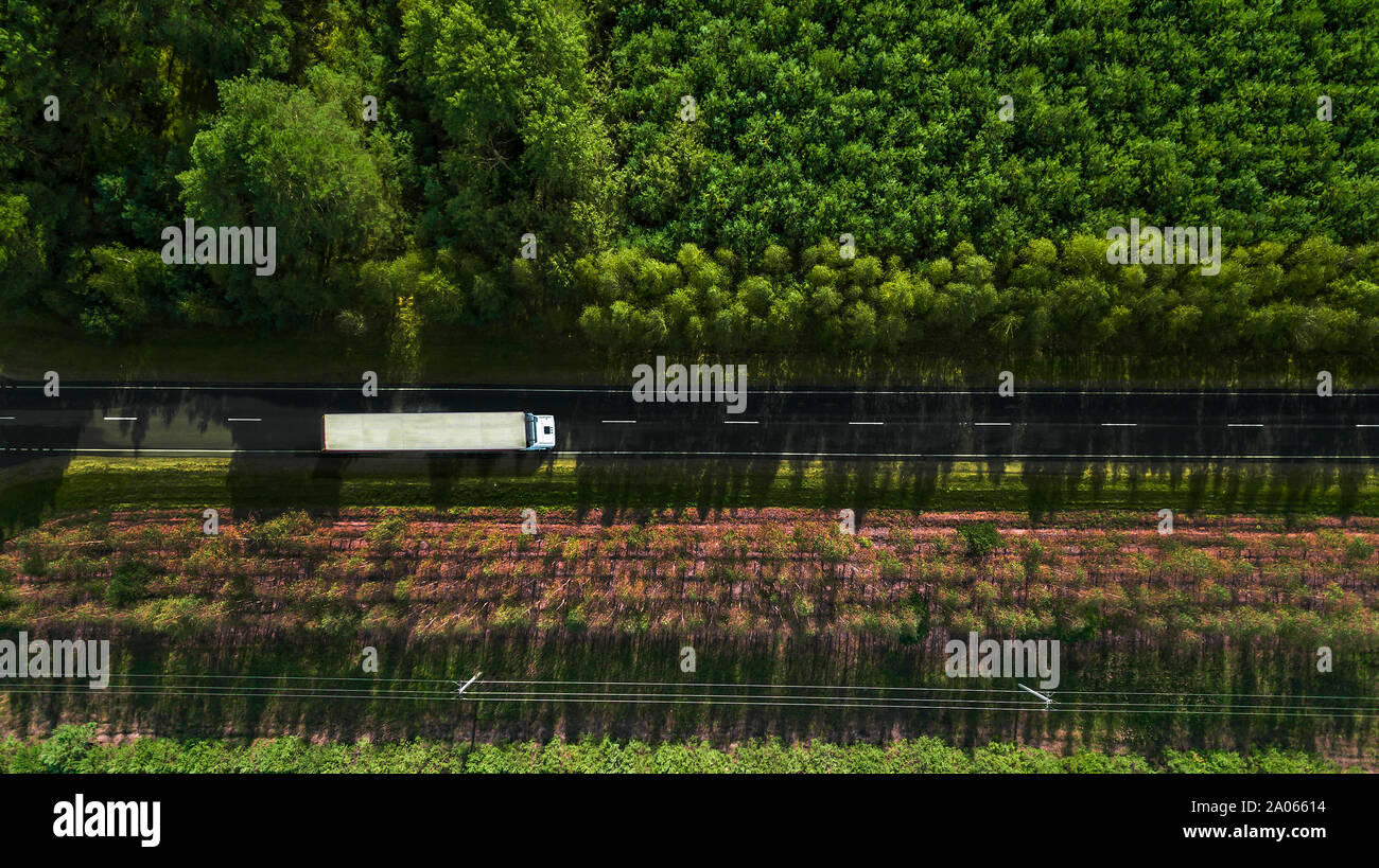 Lkw Fahren entlang einer Forststraße Luftaufnahme von einer Drohne Stockfoto