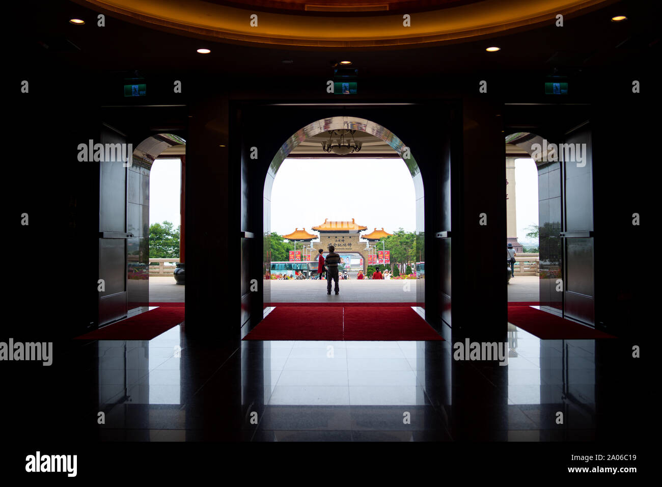 Kaohsiung, Taiwan: Silhouette der Eingang Tor Weg aus der Fo Guang Shan Buddha Museum mit Touristen und Tour Bus auf dem Parkplatz Stockfoto