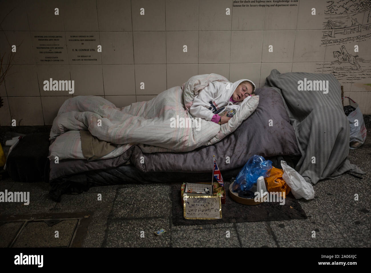 Eine obdachlose Frau schläft in einer U-Bahn zu U-Bahnhof Hyde Park Corner, London, England, Großbritannien Stockfoto