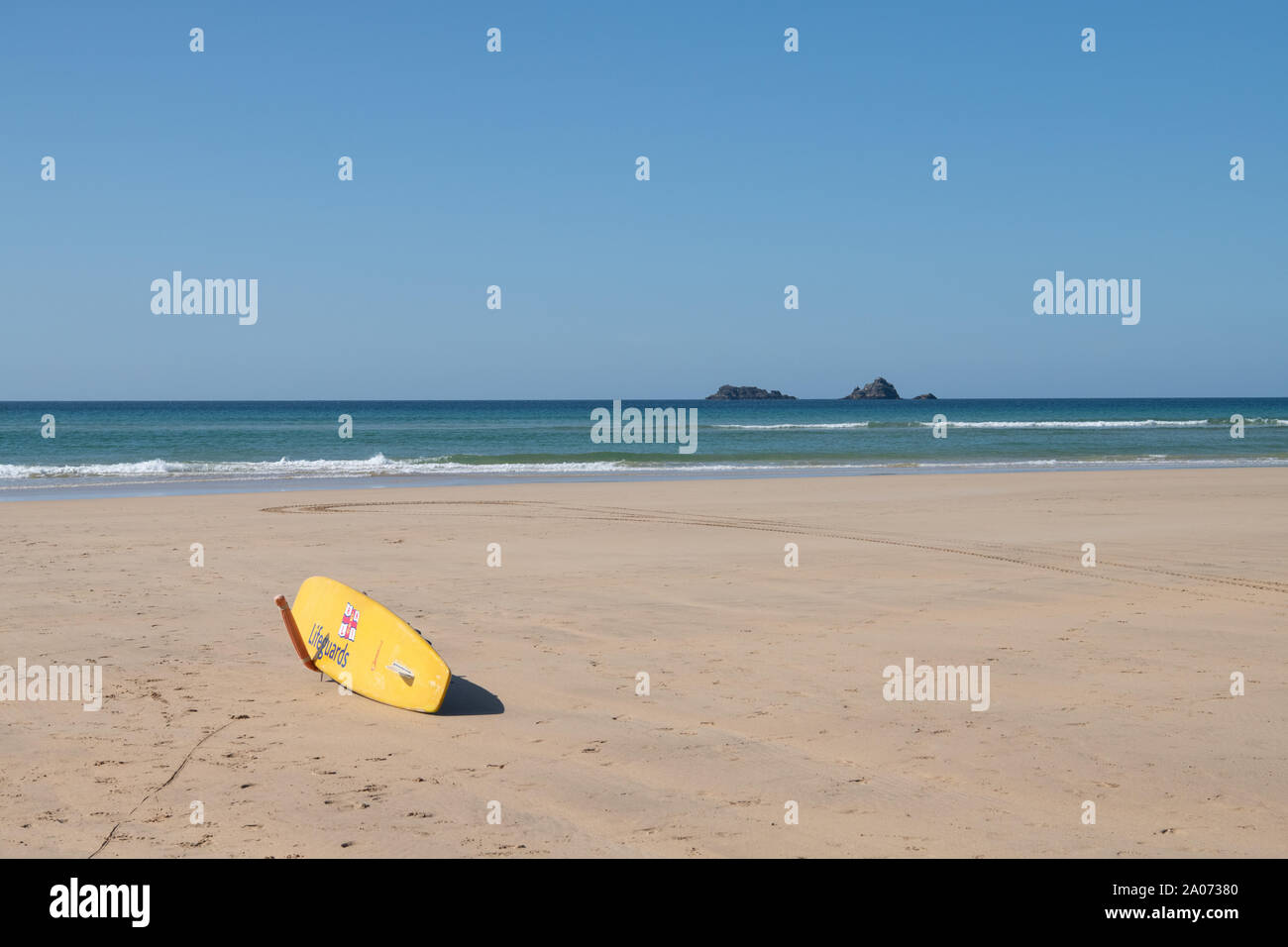 Gelbes RNLI-Surfbrett auf dem Constantine Beach, North Cornwall, England, Großbritannien Stockfoto