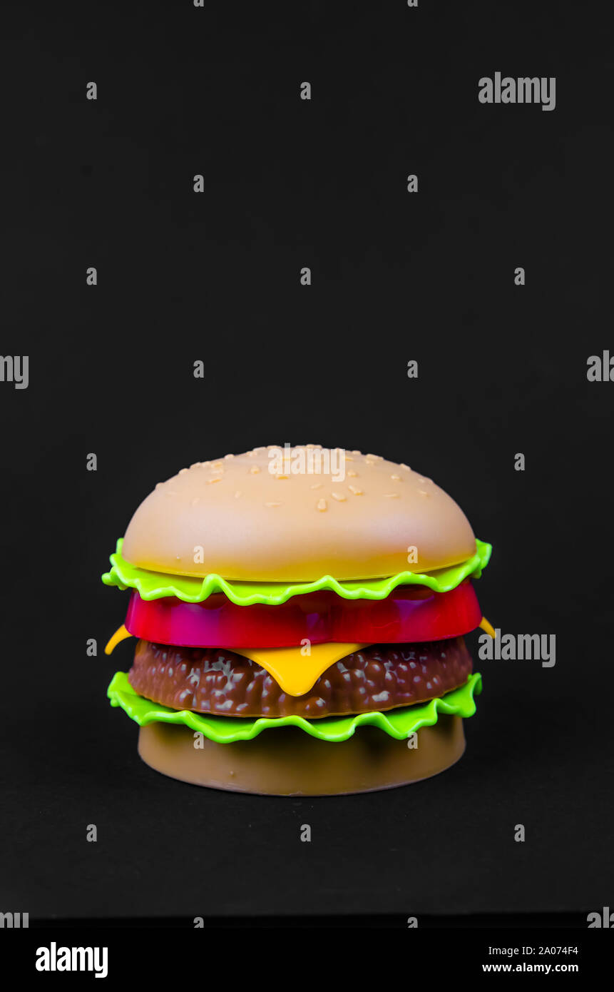 Fast food. Kunststoff Hamburger auf einem schwarzen Hintergrund. Kopieren Sie Platz Stockfoto
