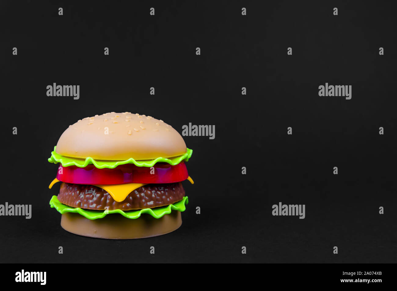 Fast food. Kunststoff Hamburger auf einem schwarzen Hintergrund. Kopieren Sie Platz Stockfoto