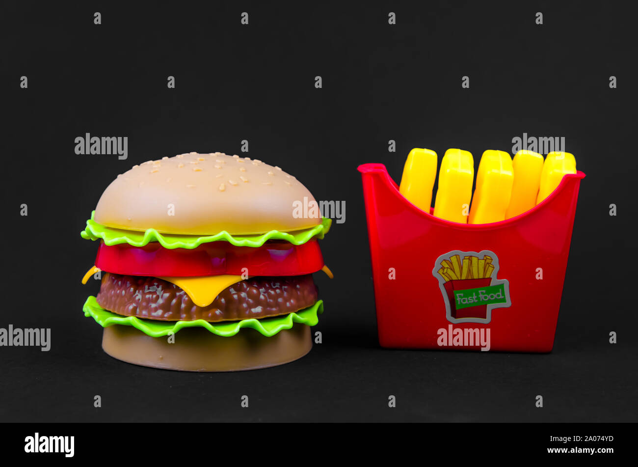 Fast food. Kunststoff Hamburger und Pommes frites auf schwarzem Hintergrund Stockfoto