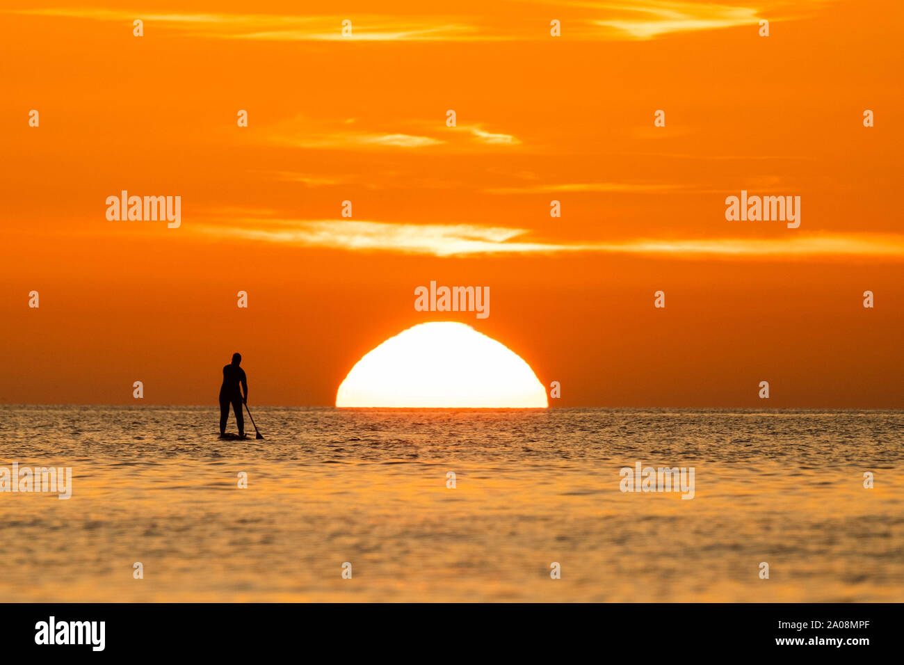 Aberystwyth Wales UK, Donnerstag, den 19. September 2019 die Sonne herrlich Einstellung über die Cardigan Bay Silhouetten Menschen auf ihre Paddel-Boards auf das Meer am Ende eines Tages des ungebrochenen klaren blauen Himmel und warmen September Sonnenschein in Aberystwyth, West Wales. Als 'Indian Summer' mini Hitzewelle weiterhin über die südlichen Teile der britischen Photo credit Keith Morris/Alamy leben Nachrichten Stockfoto