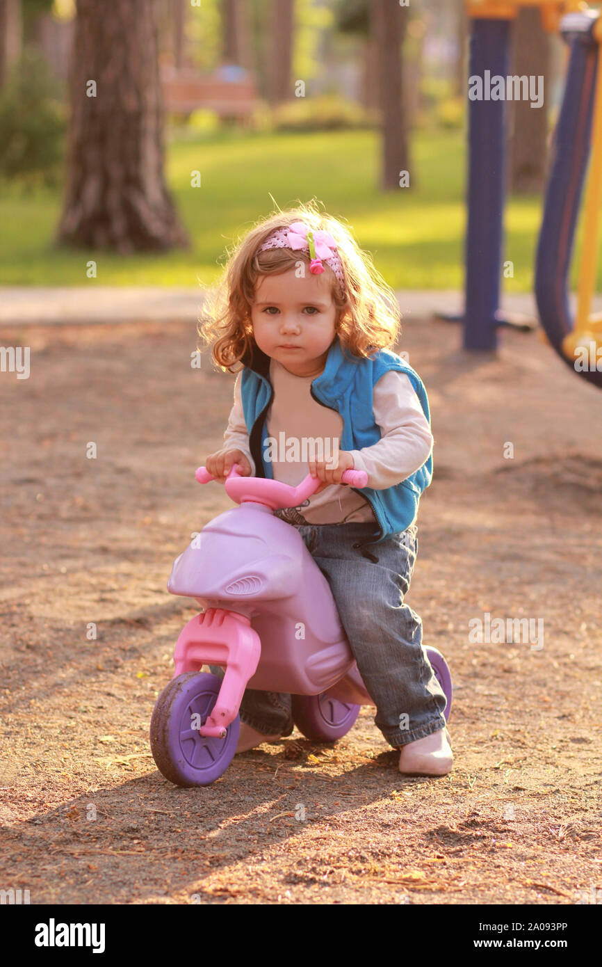 Wenig kleinkind Mädchen reiten eine kleine rosa Fahrrad im sonnendurchfluteten Sommer Park Stockfoto