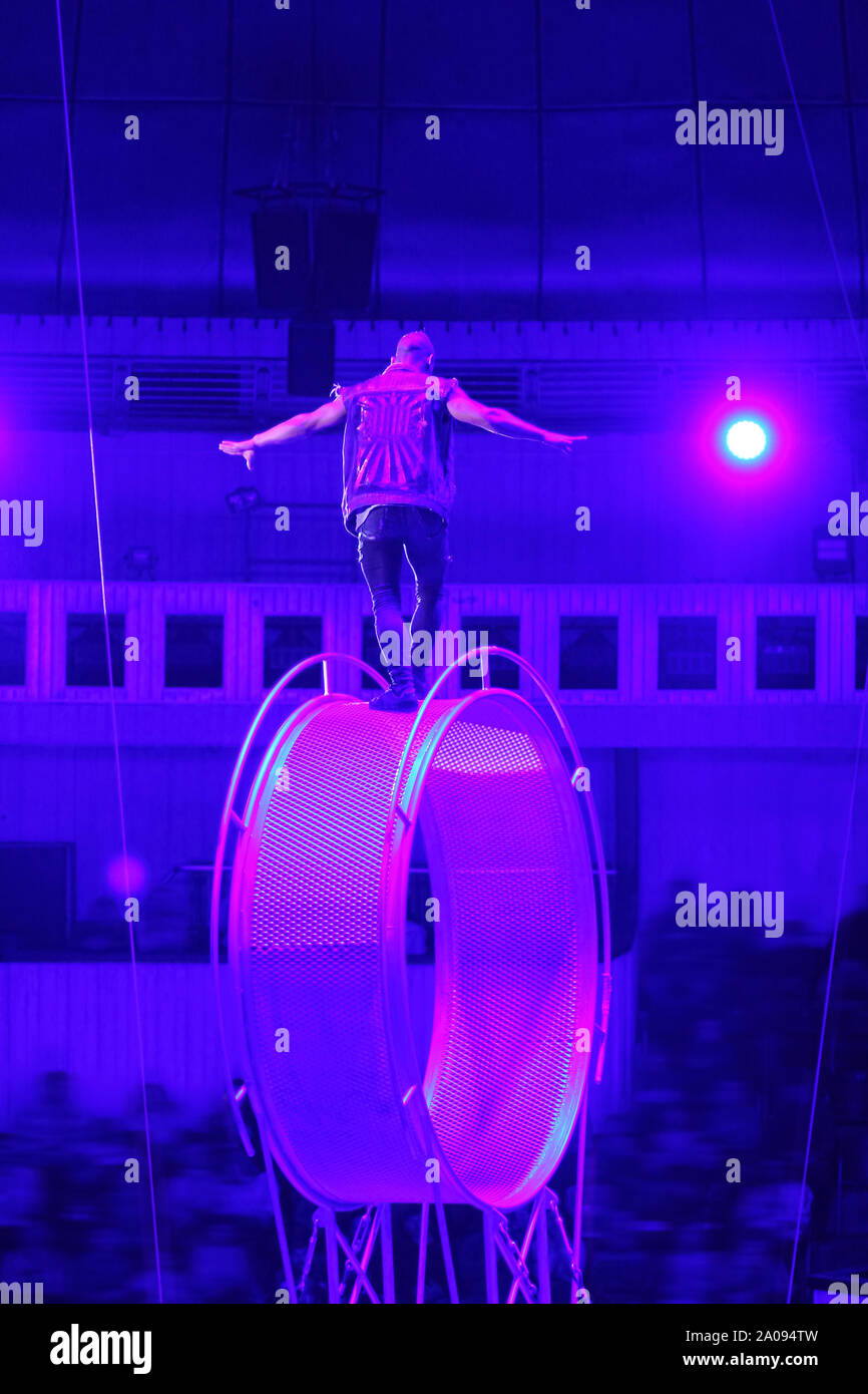 Circus performer/Acrobat auf das sich drehende Rad des Todes/Space Wheel. Gefährliche Arbeit. Stockfoto