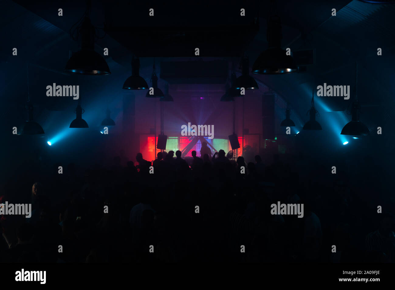 Techno Night Club mit einem clubbing Publikum und ein DJ hinter einem Drehtisch Stockfoto