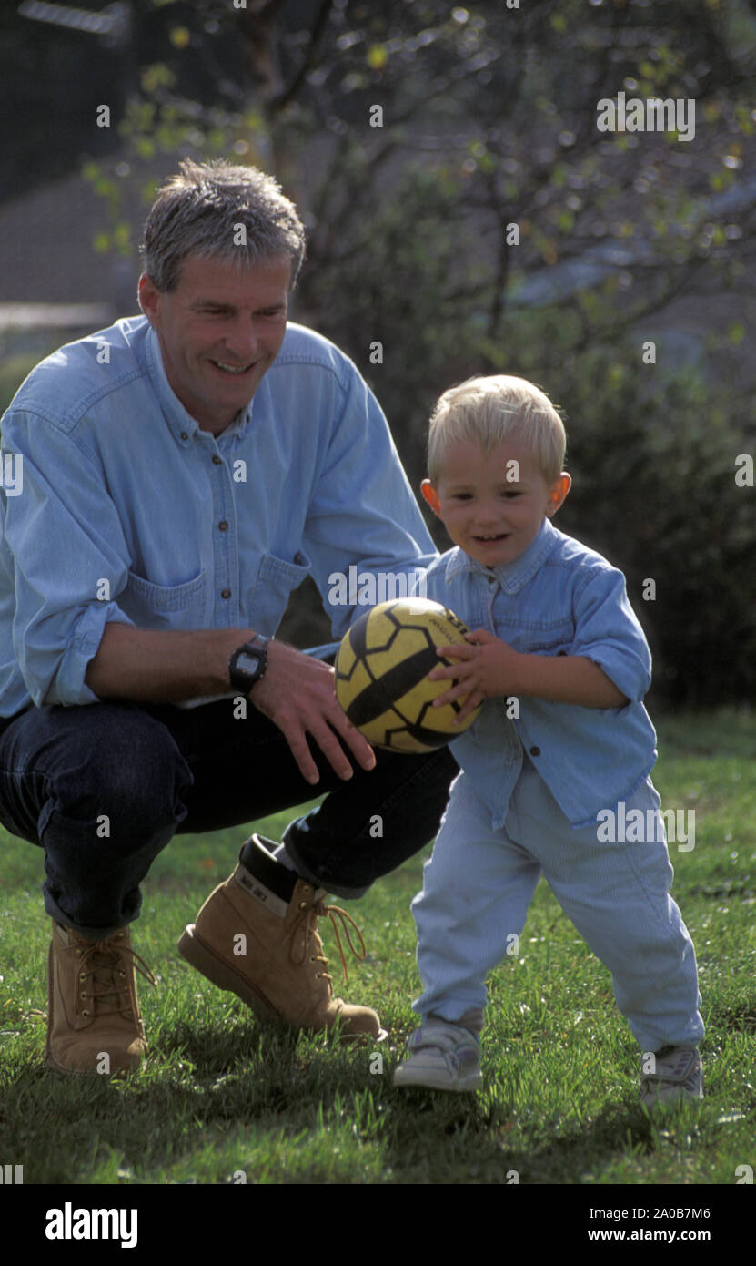 Vater und Sohn Ball spielen im Garten Stockfoto