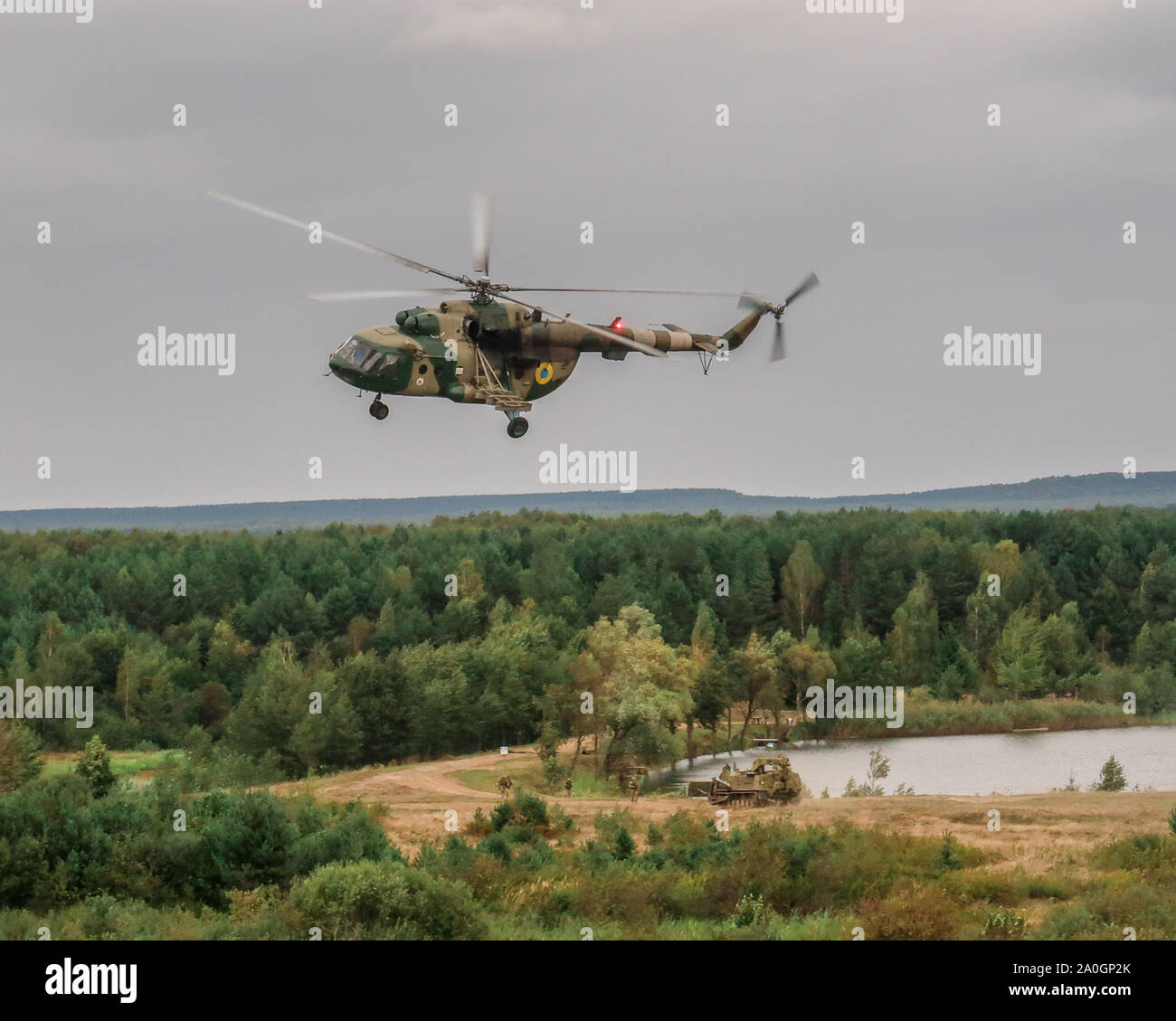 A Mi-17 Helikopter bietet brand Unterstützung für den Kampf gegen Ingenieure durchführen werden, um während der nassen Spalt Kreuzung Probe als Teil der Schnellen Trident2019 in Combat Training Center-Yavoriv, Sept. 18, 2019 durchgeführt ist der 10 Mountain Assault Brigade. Stockfoto