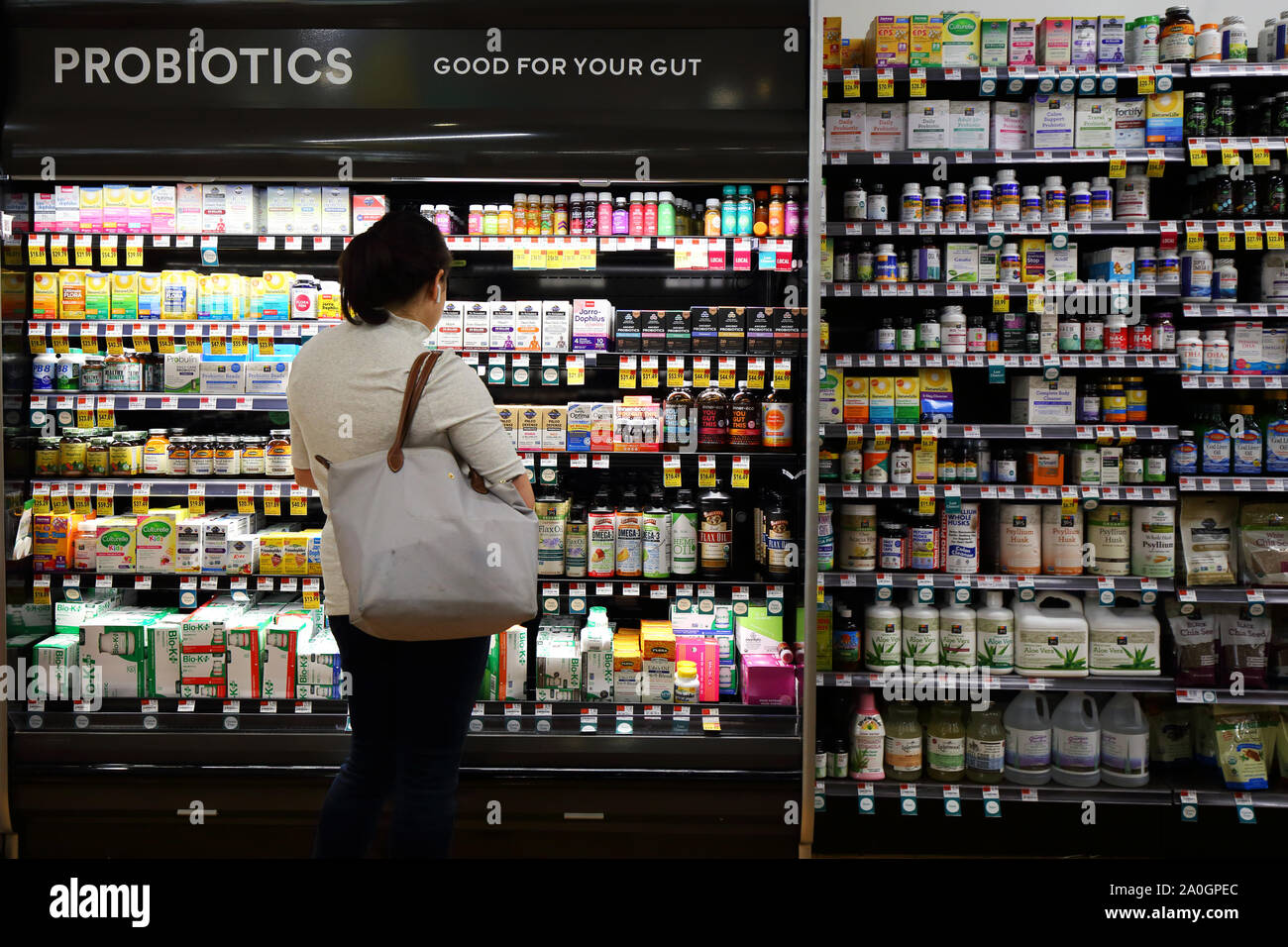 Eine Frau sucht die Probiotika Display Case zu einem natürlichen Lebensmittel Markt Stockfoto
