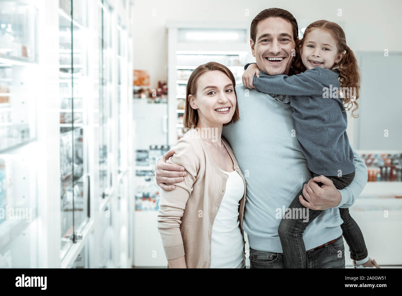 Freundliche Familie lächelnd und umarmen einander in der Apotheke Stockfoto