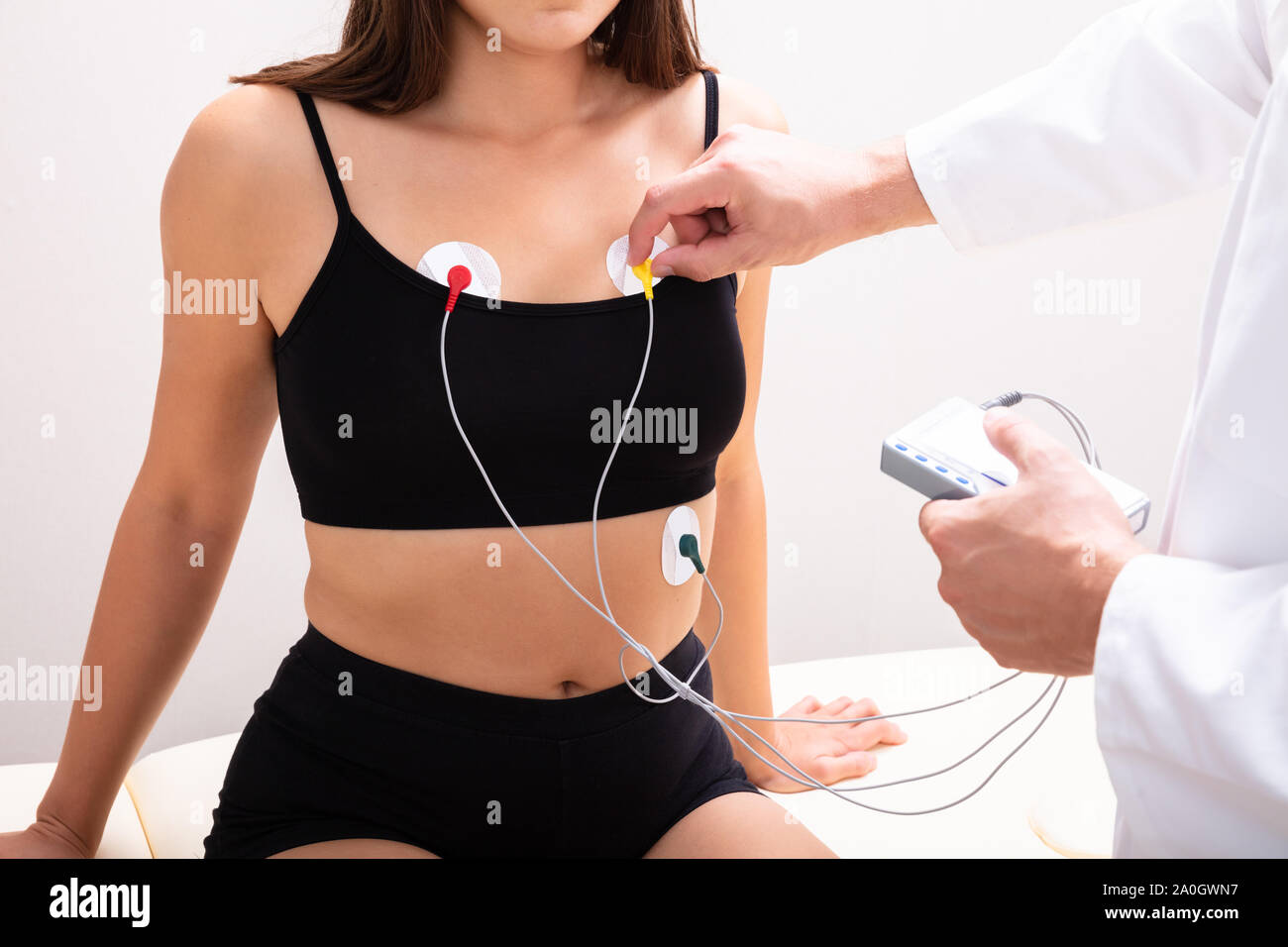 Arzt anwenden Holter-monitor Gerät am Körper der Frau für die tägliche Überwachung der Ein Elektrokardiogramm Stockfoto