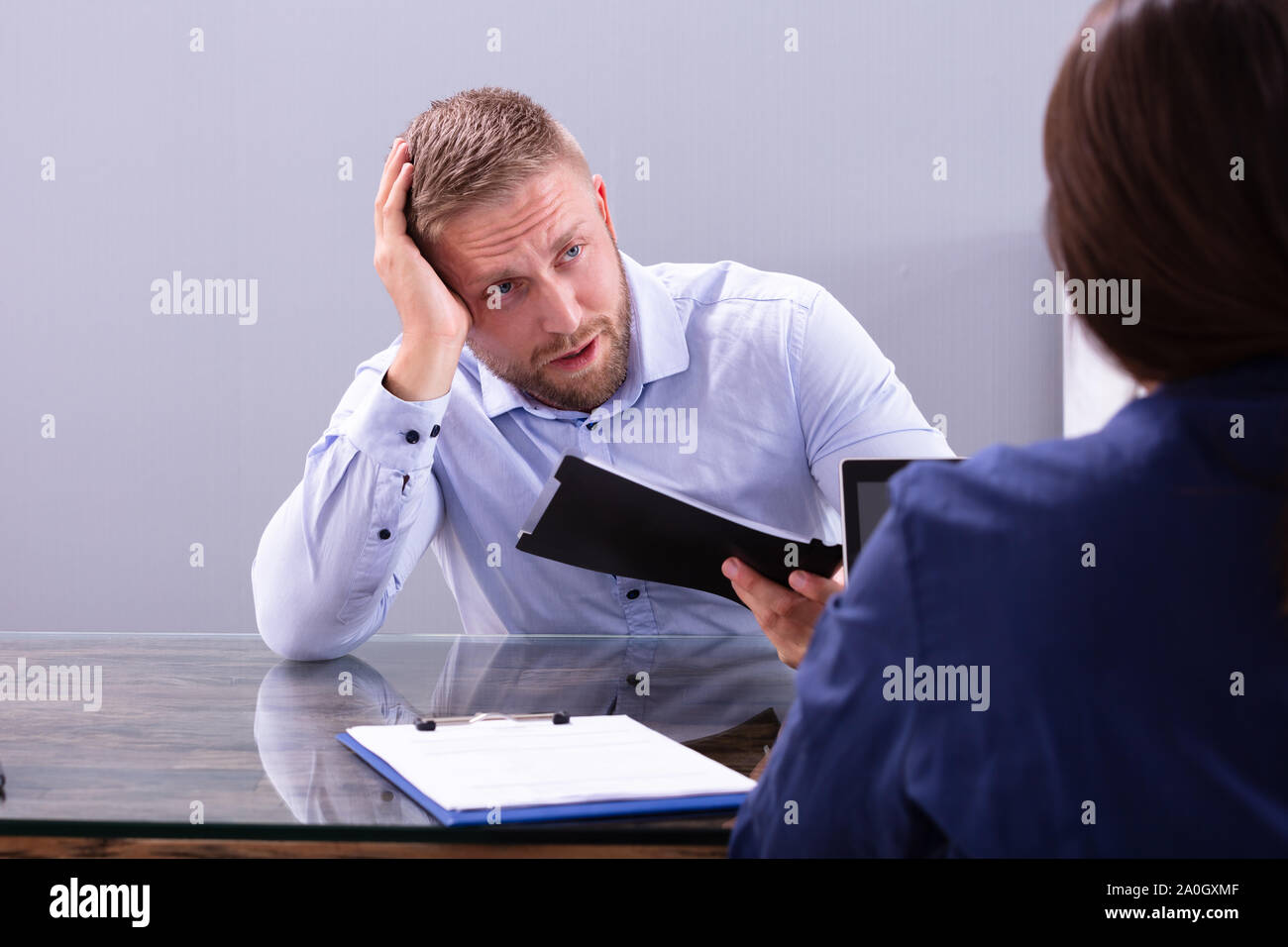 Betont Young Business Mann hält seinen Kopf an Interview im Büro Stockfoto