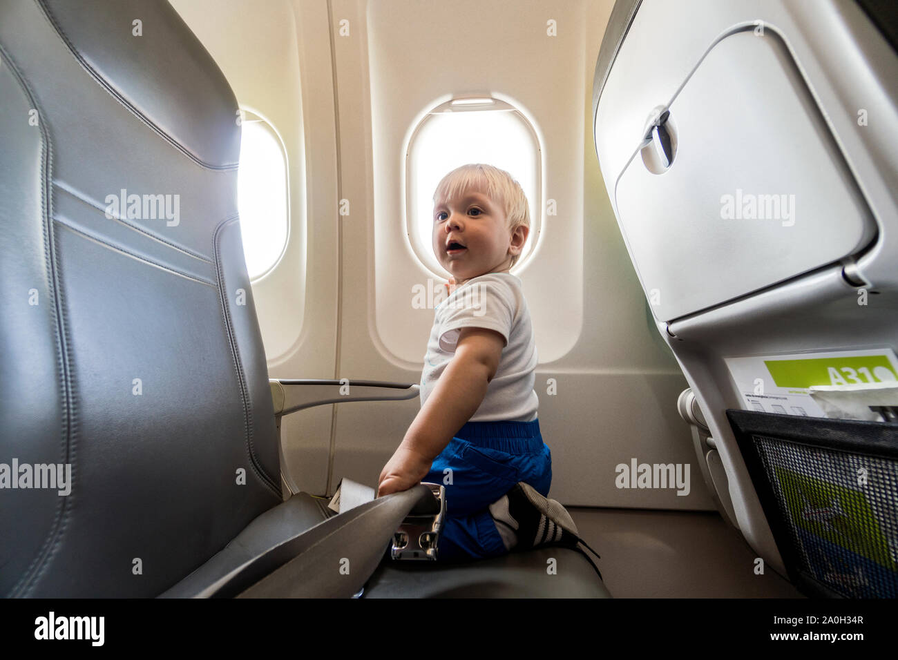 Glücklich und aufgeregt, ein Jahr alten baby boy von der Flugzeug Fenster Stockfoto