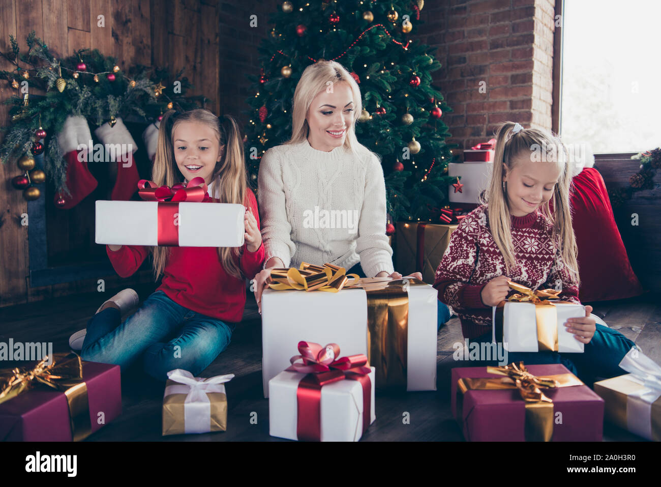 Holly Jolly x der Winter! Volle Beine Körper Größe froh, heiter charmanten Art stilvolle blonde Mutter und zwei kleinen vor - jugendlich Nachkommen in weicher Pullover sitzen auf Stockfoto