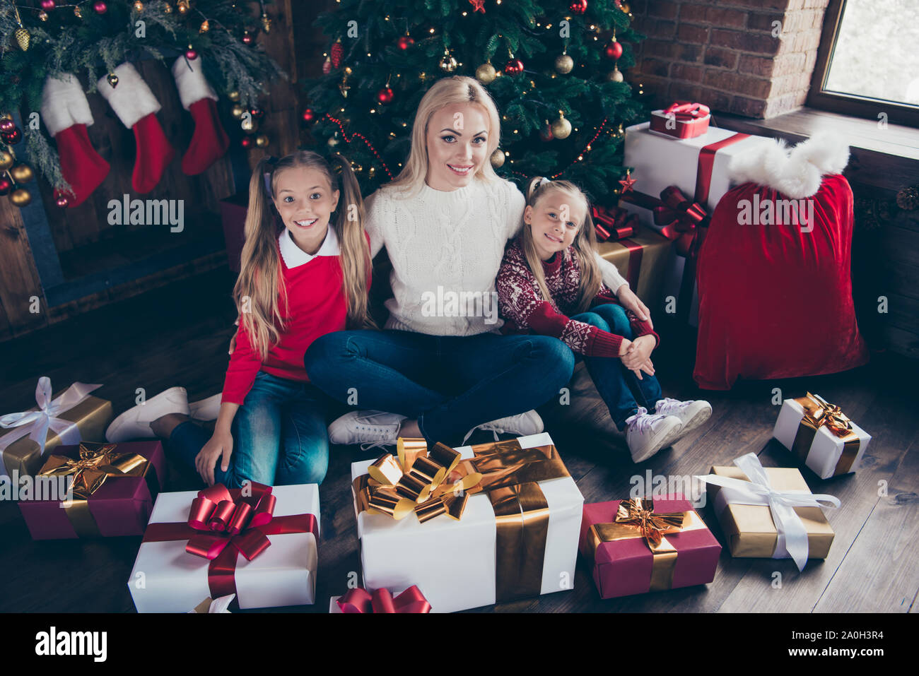 Süße noel Momente. Holly Jolly x der Veranstaltung! Volle Beine Körper Größe hohen Winkel der Ansicht von oben Sorglos blond Kuscheln zu zwei vor - jugendlich Nachkommen in weicher Pullover Stockfoto