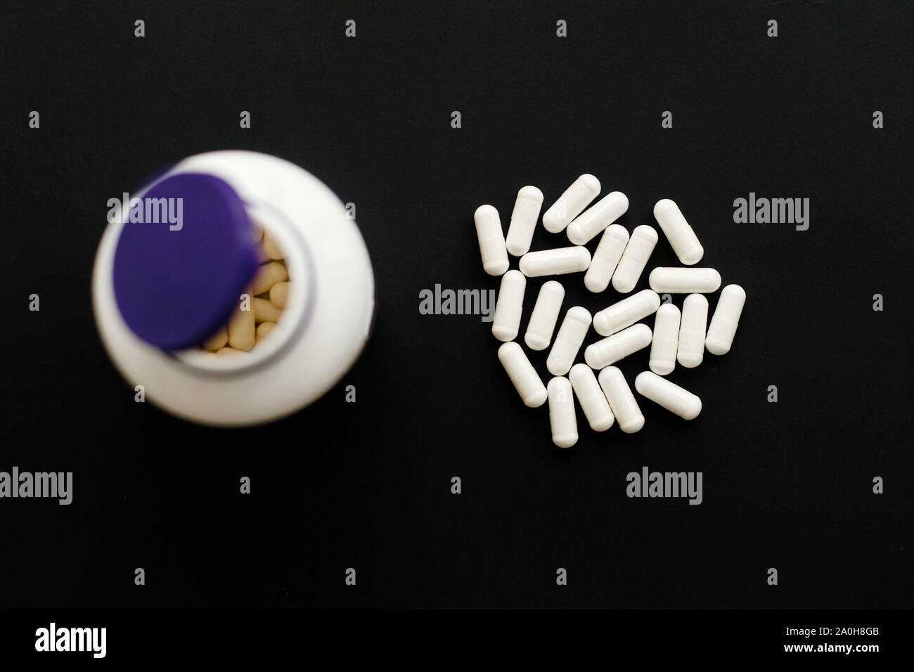Magnesium Kapseln und weiße Pillen in der Flasche Glas auf schwarzen  dunklen Hintergrund. Flach. Nahrungsergänzungsmittel. Weiße Pille.  Gesundheit Unterstützung und Behandlung. Bi Stockfotografie - Alamy