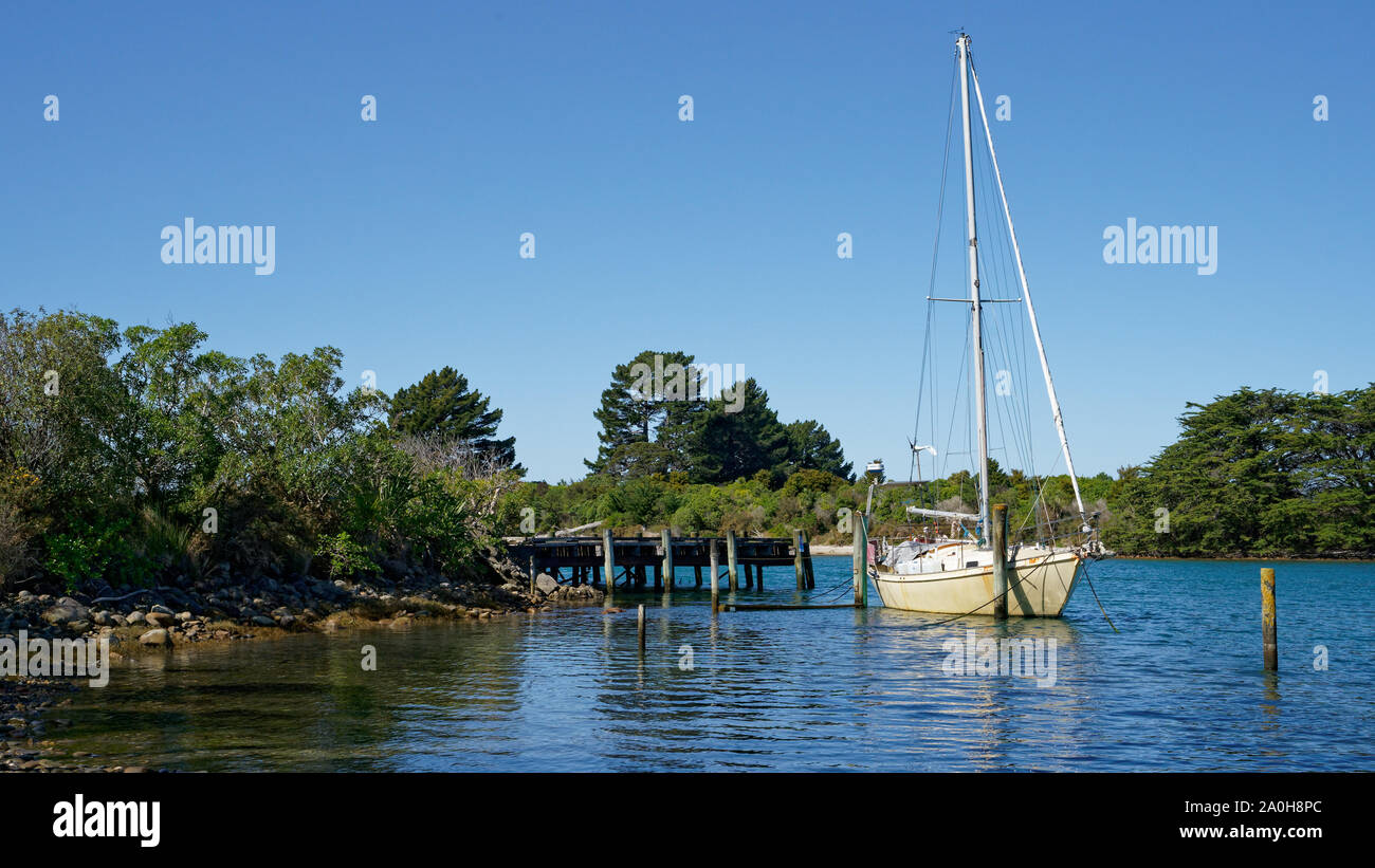 Milnthorpe Kai mit einem verankerten Yacht in Golden Bay, Neuseeland. Stockfoto