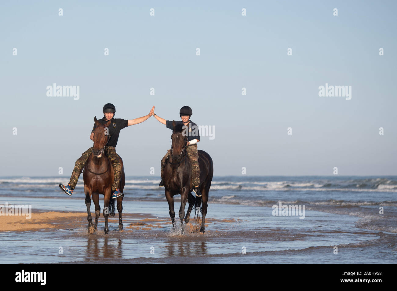 Soldaten und Pferde aus der King's Troop Royal Horse artillery Übung im Meer bei Holkham in Norfolk, als sie eine Pause von Ihrer zeremoniellen Pflichten in London. Stockfoto