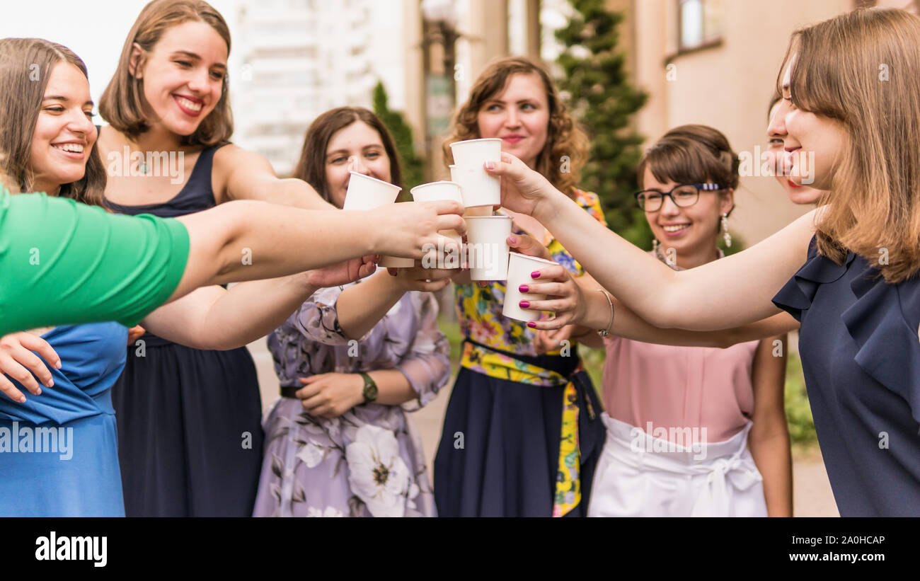 Gruppe Freundinnen Toasten mit Champagner in Papier Glas. Junge Menschen feiern mit Champagner bei der Party im Freien. Konzept der hen-Partei oder corpor Stockfoto