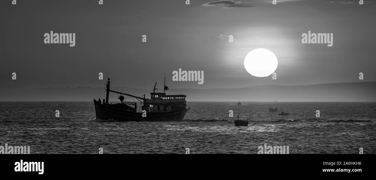 Meer Landschaft bei Sonnenuntergang, wenn die Fischerboote auf dem Meer Fisch zu ernten, den Tag ausklingen zu lassen. Stockfoto