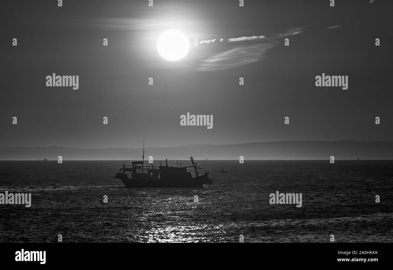 Meer Landschaft bei Sonnenuntergang, wenn die Fischerboote auf dem Meer Fisch zu ernten, den Tag ausklingen zu lassen. Stockfoto