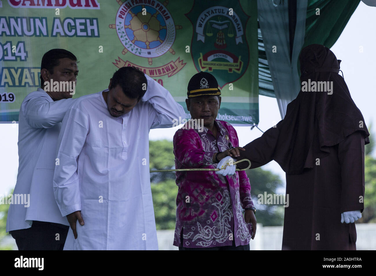 Lhokseumawe, Aceh, Indonesien. 20 Sep, 2019. Beamte, die Zeuge der Scharia Beamte der Mann, gefangen wurde und eine Affäre mit einer anderen Frau, die auf der Rückseite während der Satz in einem Stadion in Lhokseumawe, Aceh zu peitschen. Die Paare, die erwischt wurden und eine Affäre waren 9 mal jeden für das Verletzen der islamischen Scharia in Aceh, die die konservativen Provinz des Islamischen Rechts in Indonesien gepeitscht. Credit: zikri Maulana/ZUMA Draht/Alamy leben Nachrichten Stockfoto