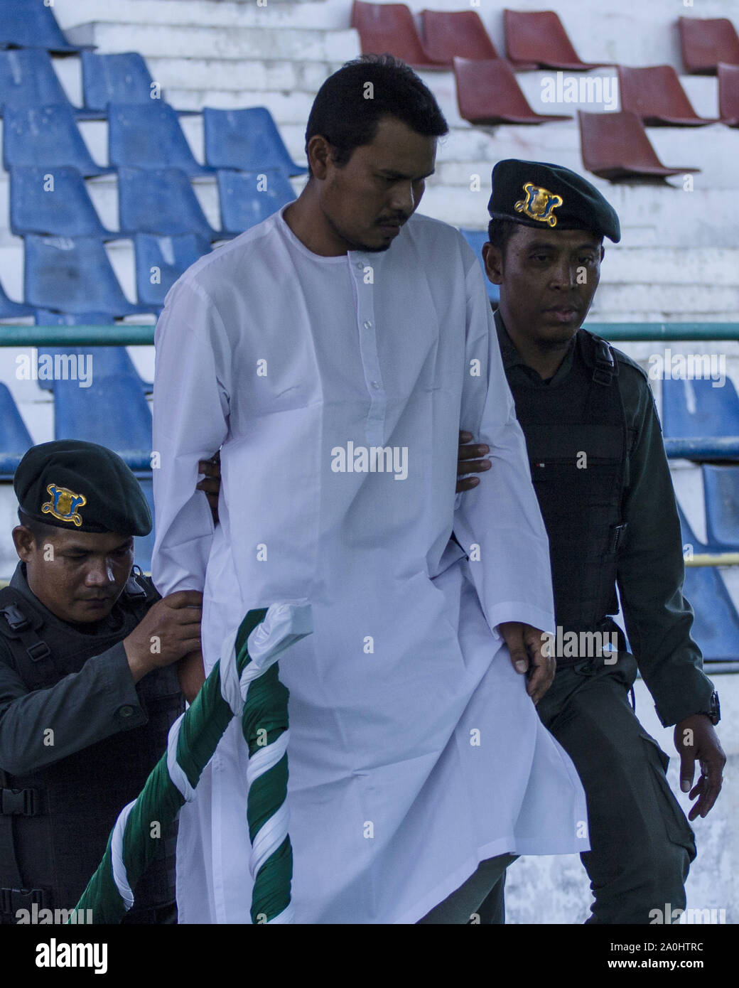 Lhokseumawe, Aceh, Indonesien. 20 Sep, 2019. Sharia- Polizei brachte ein Mann, gefangen wurde und eine Affäre mit einer anderen Frau durch die Scharia Beamte an ein Stadion in Lhokseumawe, Aceh prügelten. Die Paare, die erwischt wurden und eine Affäre waren 9 mal jeden für das Verletzen der islamischen Scharia in Aceh, die die konservativen Provinz des Islamischen Rechts in Indonesien gepeitscht. Credit: zikri Maulana/ZUMA Draht/Alamy leben Nachrichten Stockfoto