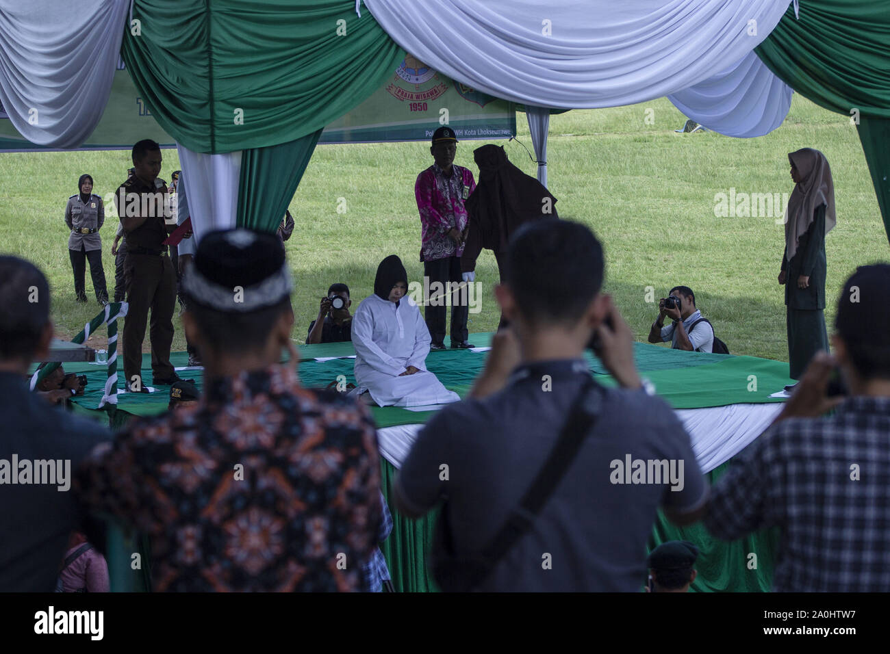 Lhokseumawe, Aceh, Indonesien. 20 Sep, 2019. Eine Frau gefangen und eine Affäre mit einem anderen Mann wurde durch eine Scharia Beamter an ein Stadion in Lhokseumawe, Aceh gepeitscht. Die Paare, die erwischt wurden und eine Affäre waren 9 mal jeden für das Verletzen der islamischen Scharia in Aceh, die die konservativen Provinz des Islamischen Rechts in Indonesien gepeitscht. Credit: zikri Maulana/ZUMA Draht/Alamy leben Nachrichten Stockfoto