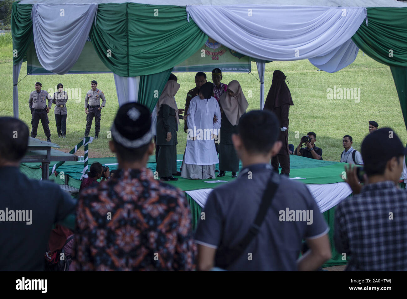 Lhokseumawe, Aceh, Indonesien. 20 Sep, 2019. Eine Frau gefangen und eine Affäre mit einem anderen Mann bereitet durch die Scharia Beamte an ein Stadion in Lhokseumawe, Aceh gepeitscht werden. Die Paare, die erwischt wurden und eine Affäre waren 9 mal jeden für das Verletzen der islamischen Scharia in Aceh, die die konservativen Provinz des Islamischen Rechts in Indonesien gepeitscht. Credit: zikri Maulana/ZUMA Draht/Alamy leben Nachrichten Stockfoto