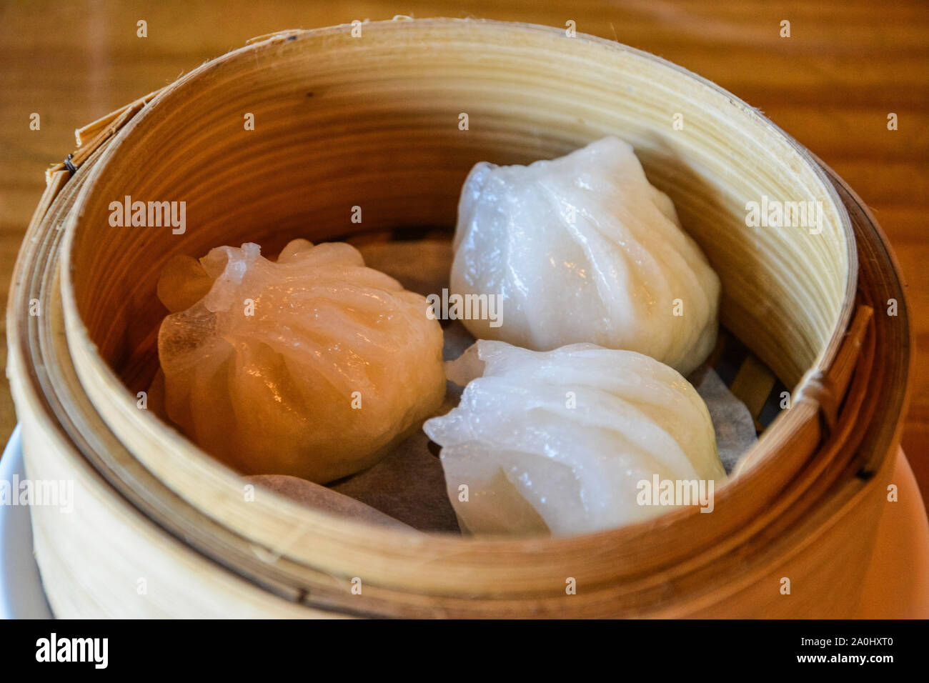 Chinesische Dim Sum Knödeln in kleinen Dampferkorb serviert. Stockfoto