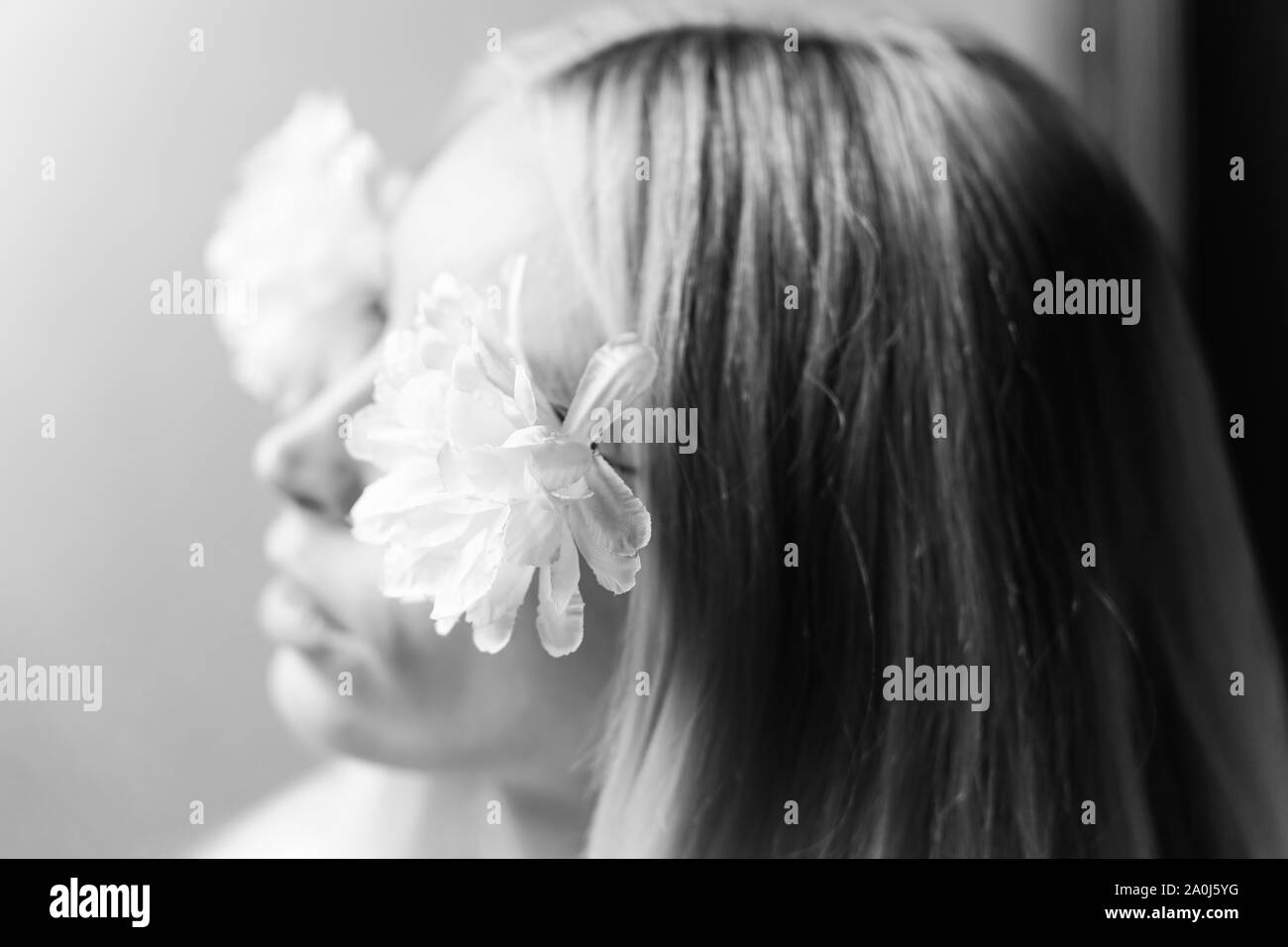 Verschwommene Portrait eines jungen Mädchen mit Blumen im Haar, weibliche Träume und Vergnügen. Selektive Weichzeichner. Schwarz und Weiß. Stockfoto