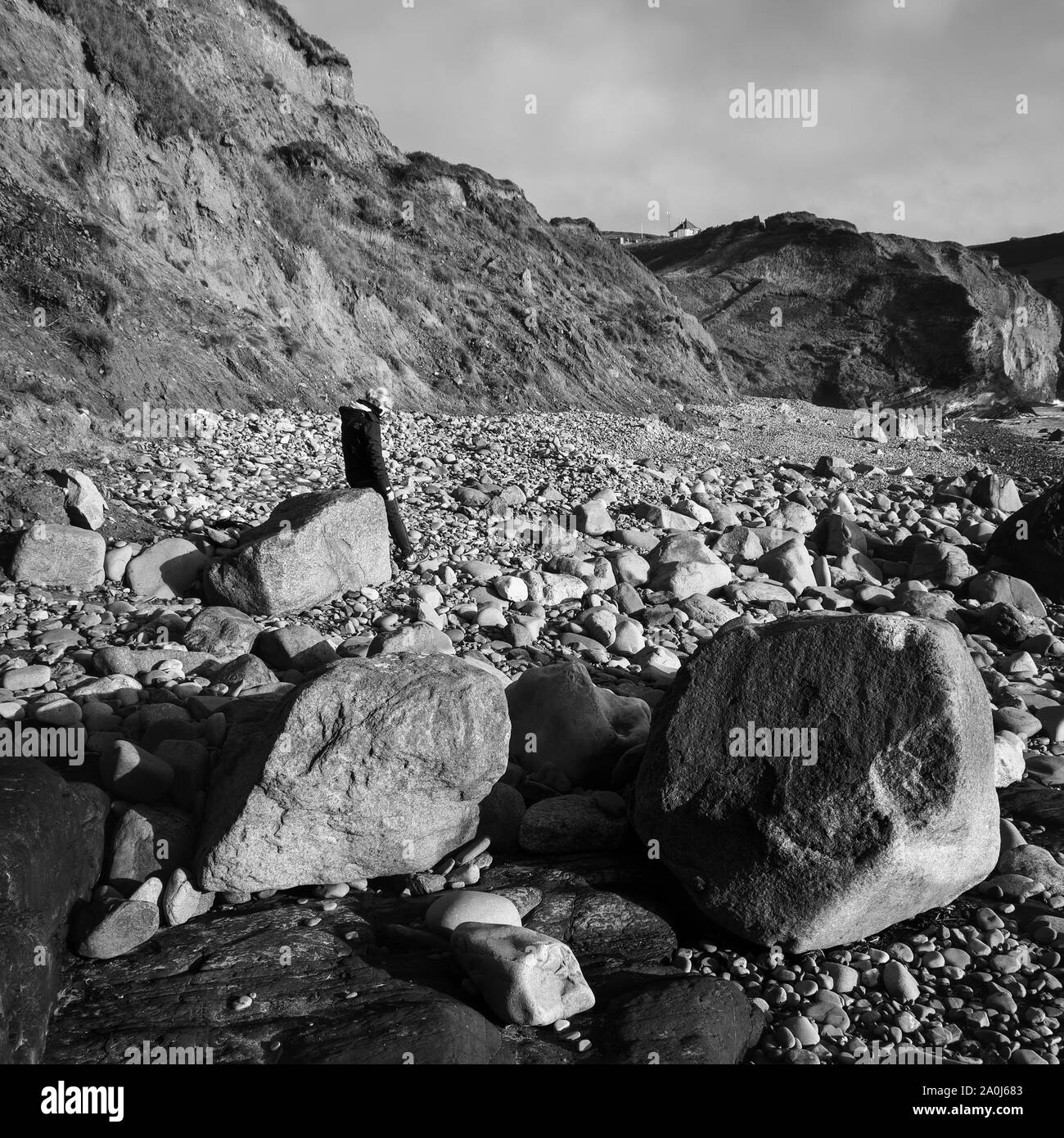 DRUIDSTON, PEMBROKESHIRE/UK - 11. SEPTEMBER: Frau sitzt auf einem Felsen am Druidston Haven Pembrokeshire am 11. September 2019. Eine nicht identifizierte Frau Stockfoto