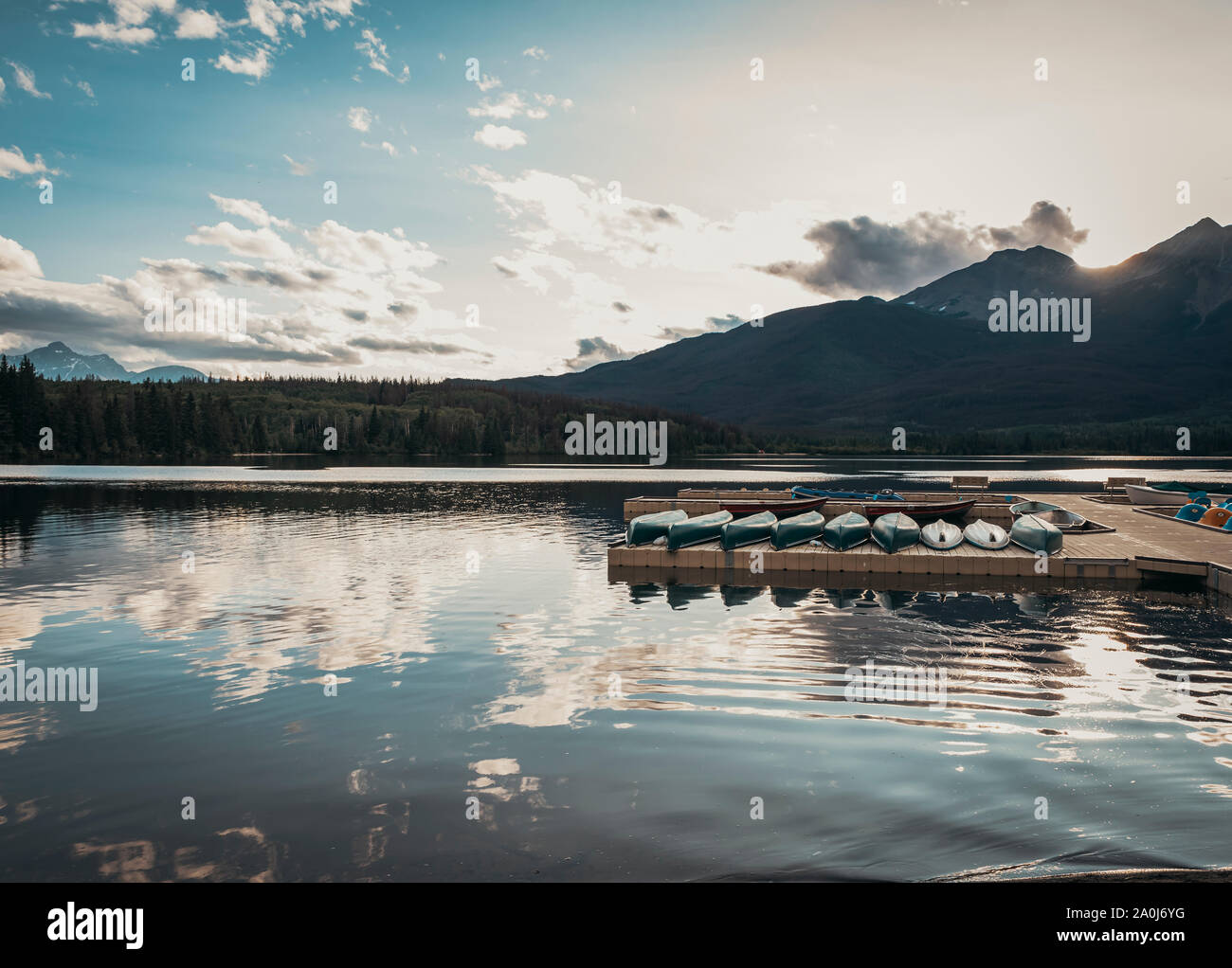 Leitung von Kanus auf einem Dock bei Sonnenuntergang auf Pyramid Lake in Jasper, Alberta. Stockfoto