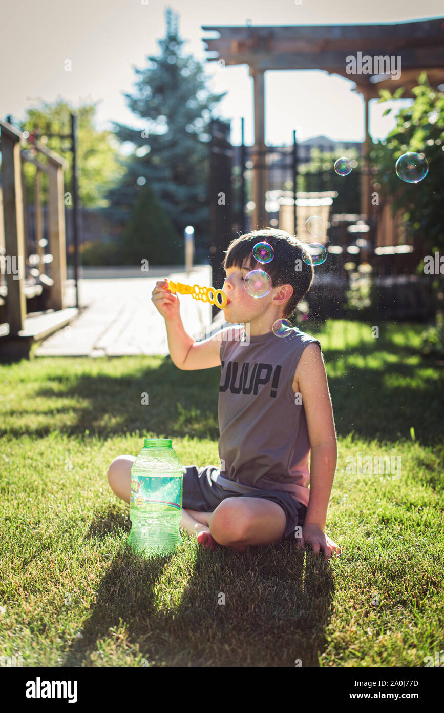 Junge Blasen Blasen in einem Hinterhof an einem Sommertag. Stockfoto